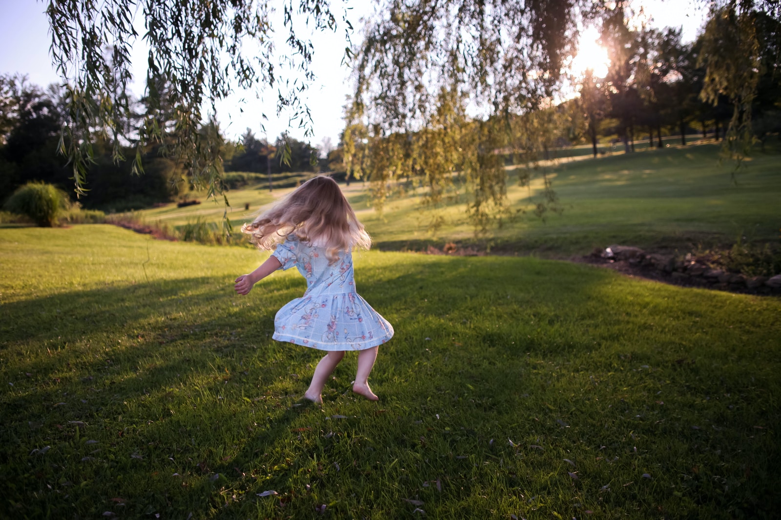 girl dancing on green grass field