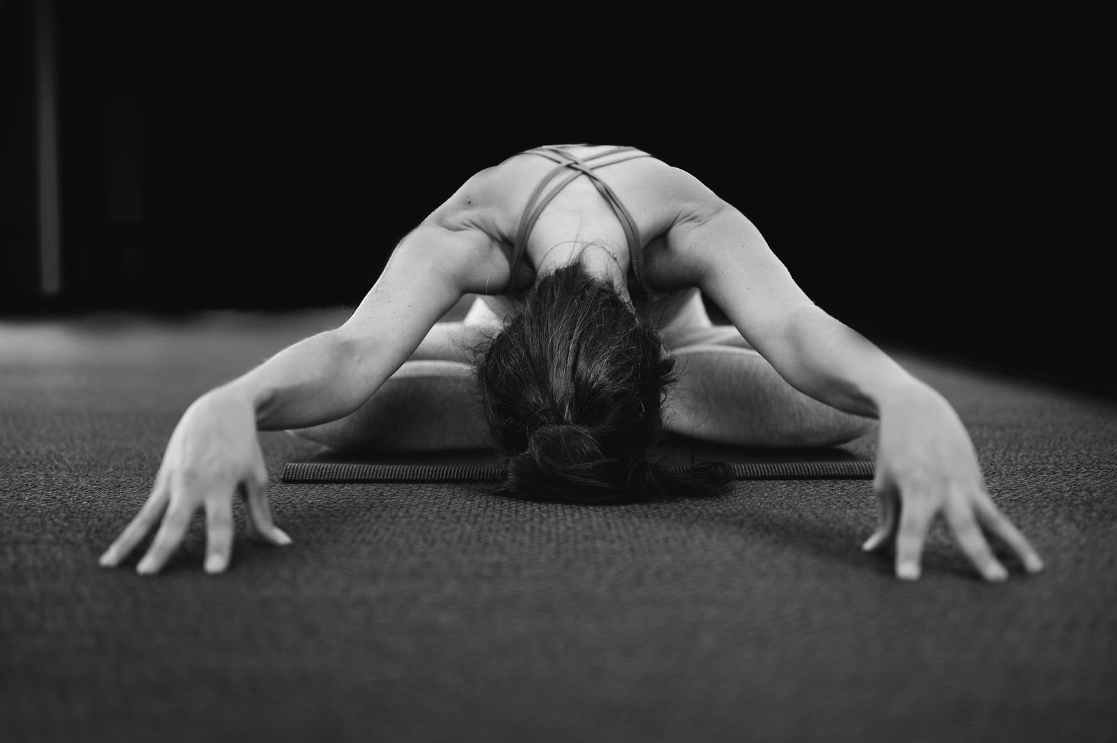woman in white tank top bending her body on floor